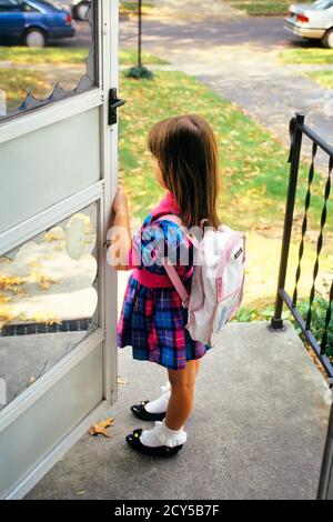 90ER JAHRE MÄDCHEN MIT RUCKSACK AUF DER VERANDA DES HAUSES HALTEN TÜR OFFEN TRAGEN ROSA BLAU KARIERTES KLEID UND LACKLEDER SCHUHE - KS32553 NET002 HARS STIL ANGST LIFESTYLE FRAUEN ZU HAUSE LEBEN KOPIEREN RAUM IN VOLLER LÄNGE PLAID TRAURIGKEIT PATENT BRÜNETTE SCHULEN TRÄUME GRAD UND WISSEN VORWEGNAHME PRIMÄRE UNSICHER KONZEPTIONELLEN GRAD SCHULWACHSTUM JUVENILES RUCKSACK KAUKASISCHEN ETHNIZITÄT ALTMODISCH UNSICHER Stockfoto