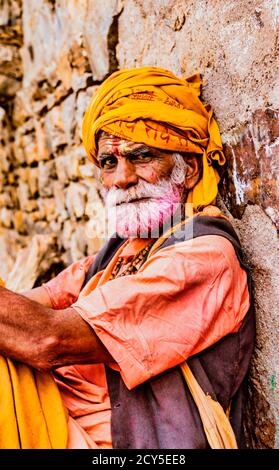 Barsana, Indien - 23. Februar 2018 - der alte Mann mit dem grauen Bart und gelbe Turbin ruht während Holi Festival Stockfoto