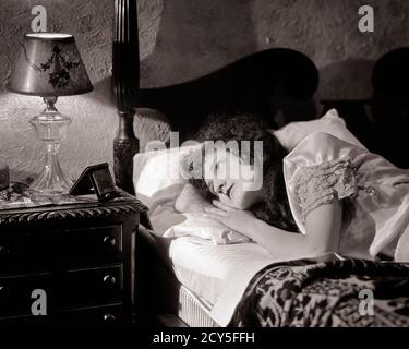 1920ER-1930ER-JAHRE SCHLAFLOS BESORGT FRAU IM BETT STARRTE AUF ALARM UHR UND LAMPE AUF NACHTTISCH - N320 HAR001 HARS FRAUEN MOODY HEALTHINESS KRANKHEIT HEIM LEBEN KOPIEREN RAUM HALB-LENGTH DAMEN KÖRPERLICHE FITNESS PERSONEN RISIKO BEUNRUHIGT B & W BESORGT TRAURIGKEIT GESUNDHEIT STARREN WELLNESS PRÄVENTION KOPF UND SCHULTERN HEILUNG UND DIAGNOSE SCHLAFLOSE GESUNDHEIT BETREUUNG BEI IM WACH BEEINTRÄCHTIGUNG STIMMUNG BEHANDLUNG BETT KONZEPTIONELL GLUM STÖRUNG MISERABLE JUNGE ERWACHSENE FRAU SCHWARZ UND WEISS KAUKASISCHEN ETHNIZITÄT KRANKHEIT HAR001 ALTMODISCH Stockfoto