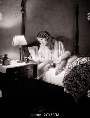 1920ER JAHRE SCHLAFLOSE FRAU WACH LIEGEND IM BETT BLICK AUF UHR AUF NACHTTISCH MIT LAMPE SCHLAFLOSIGKEIT SORGE - N555 HAR001 HARS MOODY HEALTHINESS HEIM LEBEN KOPIEREN RAUM HALBE LÄNGE DAMEN PERSONEN RISIKO AUSDRÜCKE BEUNRUHIGT B&W BESORGT TRAURIGKEIT TRÄUME WELLNESS SCHLAFLOS BEI IN AUF WACH STIMMUNG KONZEPTUELLE GLUM NACHT STEHEN MISERABEL JUNGE ERWACHSENE FRAU SCHWARZ UND WEISS KAUKASISCHEN ETHNIZITÄT HAR001 ALT MODISCH Stockfoto