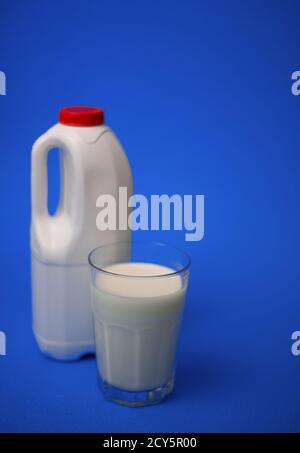 Eine Gallone Milchkännchen mit einem roten Deckel und luftdicht Vollglas Milch auf blauem Hintergrund Stockfoto