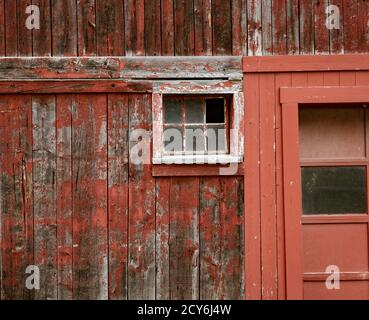 Verwitterte roter Farbe und zerbrochene Fenster sind eine gemeinsame Website auf Scheunen in Vermont. Stockfoto