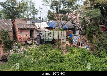 Einfache Wohnhäuser mit Plastikmüll und Wäschetrocknung in den Slums von Bhubaneswar, Indien Stockfoto