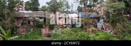 Panorama von einfachen Wohnhäusern mit Plastikmüll und Wäschetrocknung in den Slums von Bhubaneswar, Indien Stockfoto