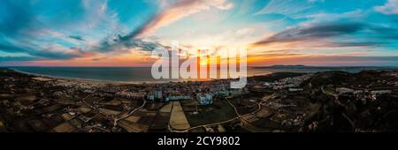 Luftpanorama von Costa Da Caparica, Portugal bei Sonnenuntergang. Küste mit herrlichen Sandstränden und mächtigen Atlantikwellen. Stockfoto