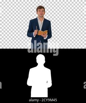 Junger Geschäftsmann denken und schreiben Notizen in seinem Notizbuch whi Stockfoto