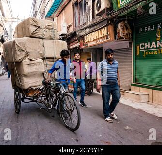 Neu Delhi, Indien, 20.Februar, 2018 - Mann trägt große Last von Getreide auf seinem Fahrrad Stockfoto