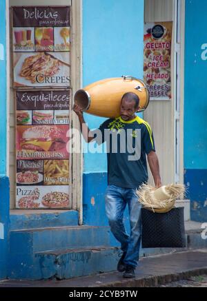 Trinidad, Kuba, Nov 26, 2017 - Man geht die Straße runter, seine Trommel auf seine Schulter und Hut in der Hand Stockfoto