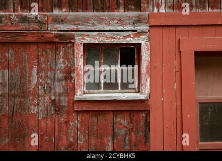 Verwitterte roter Farbe und zerbrochene Fenster sind eine gemeinsame Website auf Scheunen in Vermont. Stockfoto