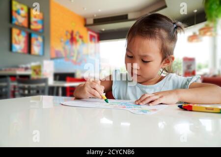 Kleines Kind beabsichtigen Färbung mit Buntstiften im Klassenzimmer.