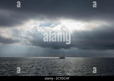 Segelboot im dunklen Meer, nur ein paar Lichtstrahlen beleuchten das Meer KOLUMBIEN Stockfoto