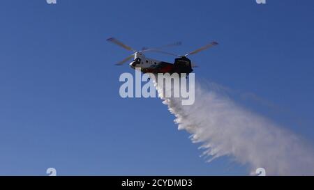 Ein CH-47 Chinook Schwerlift-Hubschrauber im Besitz und betrieben von Coulson Aviation, Inc., Tropfen Wasser auf Los Alamitos Army Airfield, September 30, 2020, für eine Flugdemonstration während einer Pressekonferenz auf Joint Forces Training Base, Los Alamitos, Kalifornien. Der Hubschrauber, der als der größte Helitanker der Welt gefeiert wird, weil er in einem einzigen Durchgang 3,000 Gallonen Wasser fallen lassen kann oder schwer entflammbar ist, ist bis Ende des Jahres auf der Basis für 24/7 Wildfire in Südkalifornien unterwegs. Der Hubschrauber kommt nach Südkalifornien durch eine Partnerschaft mit Orange County Fire Authority mit Fu Stockfoto