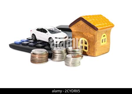 Weißes Auto mit Hausmodell mit Münzen und Taschenrechner-Konzept Geld sparen für Auto und Haus isoliert weißen Hintergrund Stockfoto