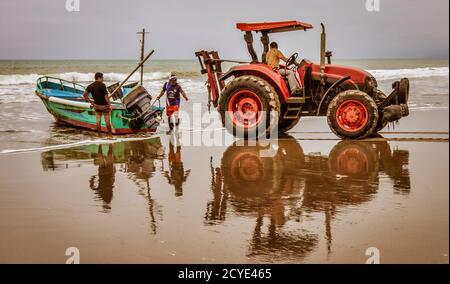 San Pedro, Ecuador - 14. September 2018 - die Fischerboote auf den Strand mit Traktor gezogen wird. Stockfoto