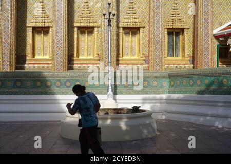 Eine Frau eilt durch den Hof des Wat Ratchabophit, Bangkok, Thailand, dem Sitz des Sangharat (Sankharaat/Sangharaja), dem Leiter des thailändischen Buddhismus Stockfoto