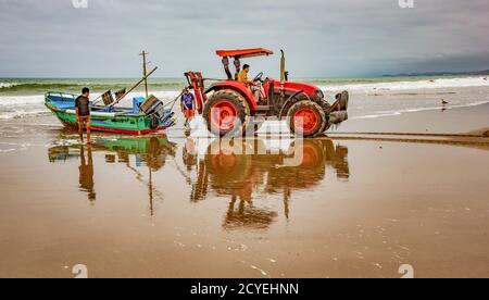 San Pedro, Ecuador - 14. September 2018 - die Fischerboote auf den Strand mit Traktor gezogen wird. Stockfoto