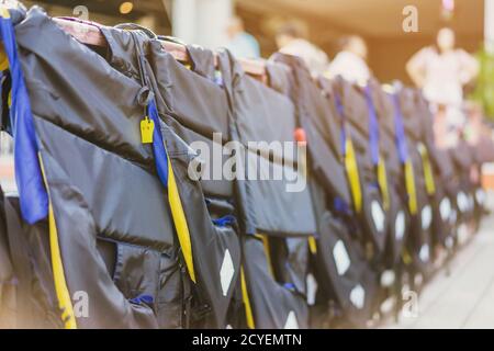 Eine gelbe Pfeife mit schwarzer Lebensjacke, die am Geländer um den Gehweg hängt, damit die Passagiere sicher an den Docks sind. Stockfoto