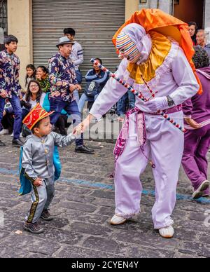 Latacunga, Ecuador - 22. September 2018 - ein Clown führt jede Nachbarschaft Gruppe in der Mama Negra Parade, seine Gruppe zu verkünden Stockfoto