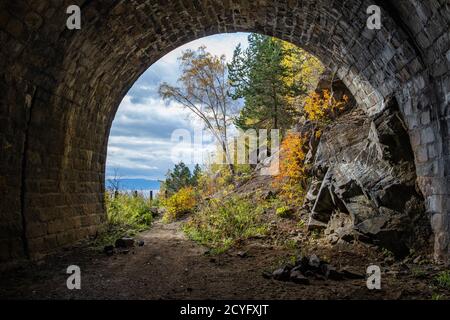 Ein herrlicher Blick aus dem Tunnel der Circum-Baikalbahn auf eine herbstliche Landschaft am Baikalsee. Tolle Natur mit bunten Wald. Stockfoto
