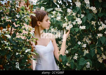 Attraktive bescheidene junge Mädchen natürlichen Make-up in einem weißen Kleid im Freien Stockfoto