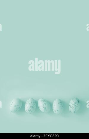 Ostereier liegen in der Reihe auf dem schlichten Hintergrund Minze-Neonatal Stockfoto