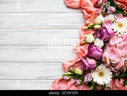 Blumenzusammensetzung. Bordüre aus rosa Blumen auf weißem Holzhintergrund. Flach liegend, Draufsicht, Kopierbereich Stockfoto