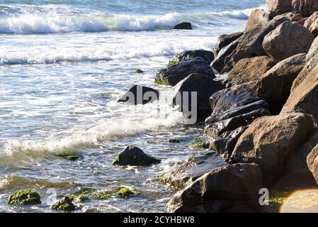 Meereswellen stürzen gegen große Felsen an der Küste ab. Stockfoto