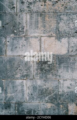 Zerkratzte Textur der grauen Betonwand aus massiven Platten. Stockfoto