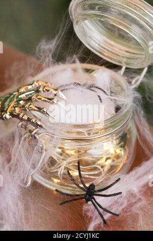 spinnennetz und Spinnen mit Girlande und Skeletthand auf braunem Hintergrund. halloween Urlaubskonzept Stockfoto