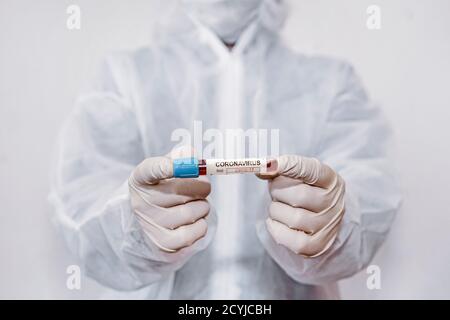 Coronavirus covid 19 infizierte Blutprobe im Probenröhrchen in Hand des Wissenschaftlers mit Biogefahrenschutzkleidung in Coronavirus covid 19 erneut auffinden Stockfoto