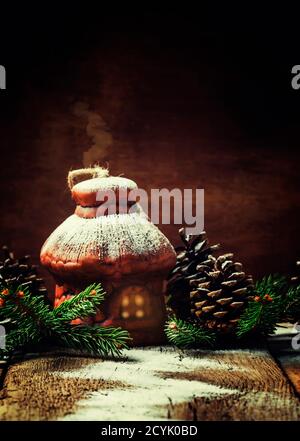 Weihnachts- oder Neujahrskomposition mit Feenhaus, Fichtenzweigen und Tannenzapfen unter dem Schnee, selektiver Fokus Stockfoto