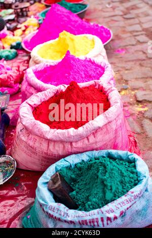 Taschen von farbigen Pulver Farbe sitzen warten auf Holi Festival Zelebranten in Barsana, Indien verkauft werden Stockfoto