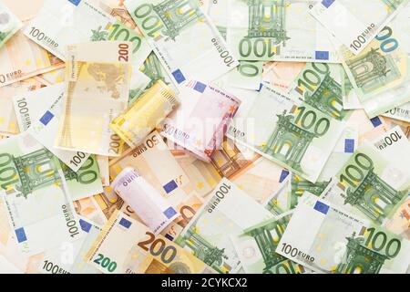 Walzen der Euro-Banknoten auf verstreut euro Geld. Unternehmen, Finanzen, Sparen, Banken- Konzept, die Wechselkurse. Frame, Kopieren, Ansicht von oben. Stockfoto