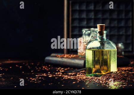 Leinöl oder Leinöl in Glasflasche und Samen, dunkler Hintergrund, selektiver Fokus Stockfoto