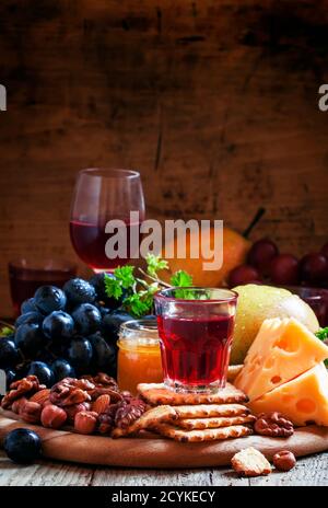 Rosenwein und Holzgericht mit verschiedenen Snacks, Vintage-Hintergrund, selektiver Fokus Stockfoto