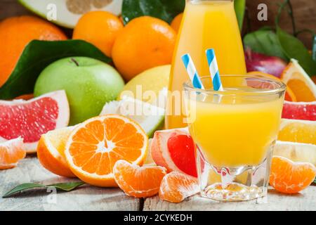 Gesunder frischer Zitruscocktail im großen Glas mit gestreiften Strohhalmen, selektiver Fokus Stockfoto