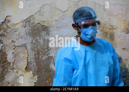 Coronavirus-Pandemie. Ein indischer Gesundheitshelfer, der PSA-Schutzanzug, Gesichtsmaske und Handschuhe trägt. Mitarbeiter im Gesundheitswesen im Zeitalter von COVID-19. Stockfoto