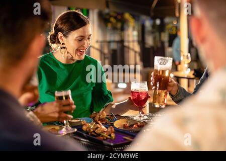 Freunde trinken Alkohol im Freien in einer Bar / Restaurant, feiern und Spaß zusammen. Stockfoto