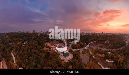 Panoramablick auf Kiew vom Himmel. Sonnenuntergang über Sommer Kiew mit Bogen der Freundschaft der Völker. Gefilmt auf Drohne. Luftaufnahme Stockfoto