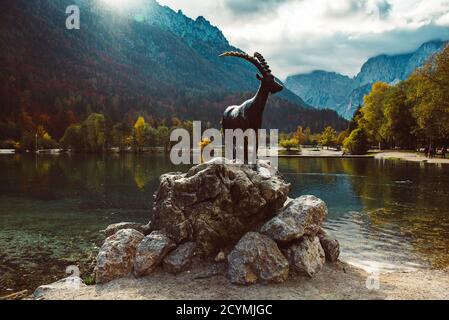 Jasna See mit dem Denkmal der Bergziege - Gämse Zlatorog vor. Nationalpark Triglav, Slowenien Stockfoto