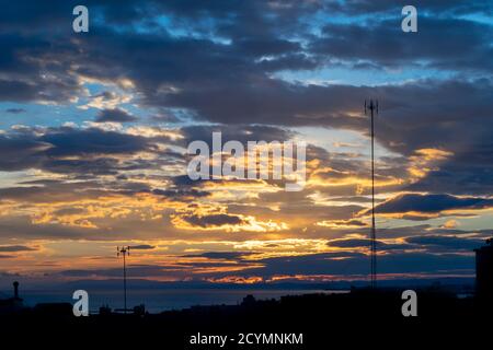 Ein farbenfroher tropischer Herbstuntergang mit Blick auf das Mittelmeer Eine Silhouette der Stadt Stockfoto