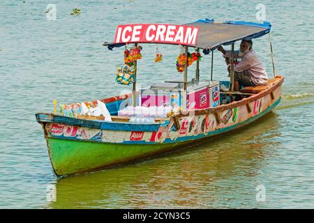 Mann, der Eis vom Boot auf dem See Vembanad auf den Backwaters verkauft, die für Hausbootkreuzfahrten populär sind; Alappuzha (Alleppey), Kerala, Indien Stockfoto