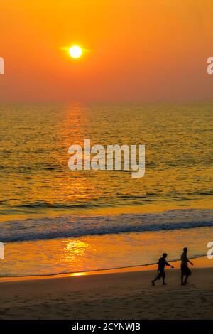 Wanderer Silhouetten bei Sonnenuntergang auf schönen, unberührten Kizhunna Strand, südlich von Kannur an der State's Nth Küste; Kannur, Kerala, Indien Stockfoto