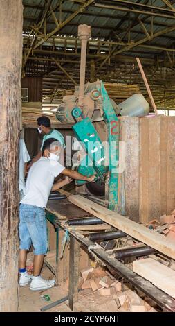 In einem Sägewerk im Industriegebiet Seguntor in Sandakan, Sabah, schneiden Arbeiter große Hölzer in Planken Stockfoto