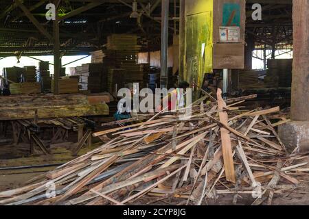 In einem Sägewerk im Industriegebiet Seguntor in Sandakan, Sabah, schneiden Arbeiter große Hölzer in Planken Stockfoto