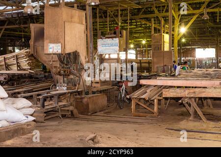 In einem Sägewerk im Industriegebiet Seguntor in Sandakan, Sabah, schneiden Arbeiter große Hölzer in Planken Stockfoto