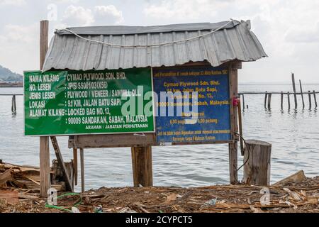 Schild an der Lieferstelle einer Sperrholzfabrik in Sandakan, Sabah, Malaysia. Die rohen Holzstämme kommen hier auf einem Lastkahn zum Entladen an. Stockfoto