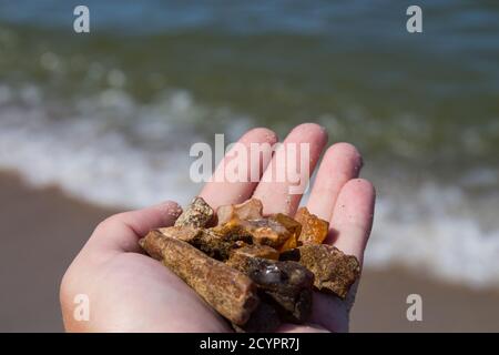 Bernstein nicht in Sand vor dem Hintergrund der Meereswellen verarbeitet. Stockfoto