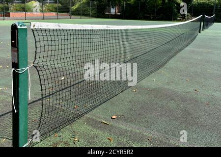 Nahaufnahme des Tennisplatzes schwarzes Netz, isoliert, ohne Spieler draußen im Herbstsonne Stockfoto