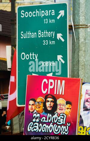 Plakat der Kommunistischen Partei von Che Guevara und indischen Führern, mit Straßenschild in der nördlichen Wayanad Region; in der Nähe von Soochipara, Wayanad, Kerala, Indien Stockfoto